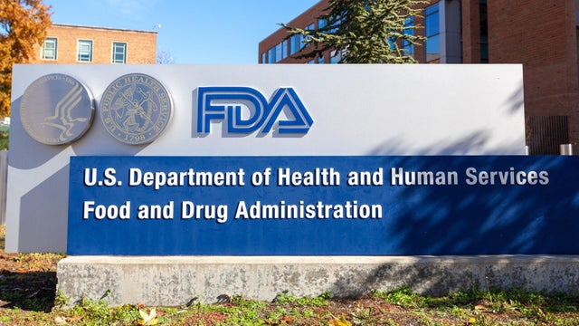 Indian Asian gas stove in kitchen with blue flame of the burner and one stainless steel tea or milk pan or chai pateela and one kadaai or iron skillet 