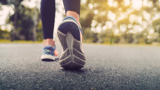 Woman feet running on road closeup on shoe. Young fitness women runner legs ready for run on the road. Sports healthy lifestyle concept. 