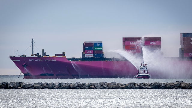 A Los Angeles City fire boat shoots a stream of water onto the deck of the container ship One Henry Hudson, currently anchored offshore, after it caught fire while docked in the Port of Los Angeles 